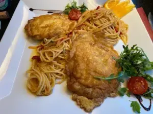 Ein Teller mit Pasta und Hähnchen, liebevoll angerichtet und bereit zum Genießen.